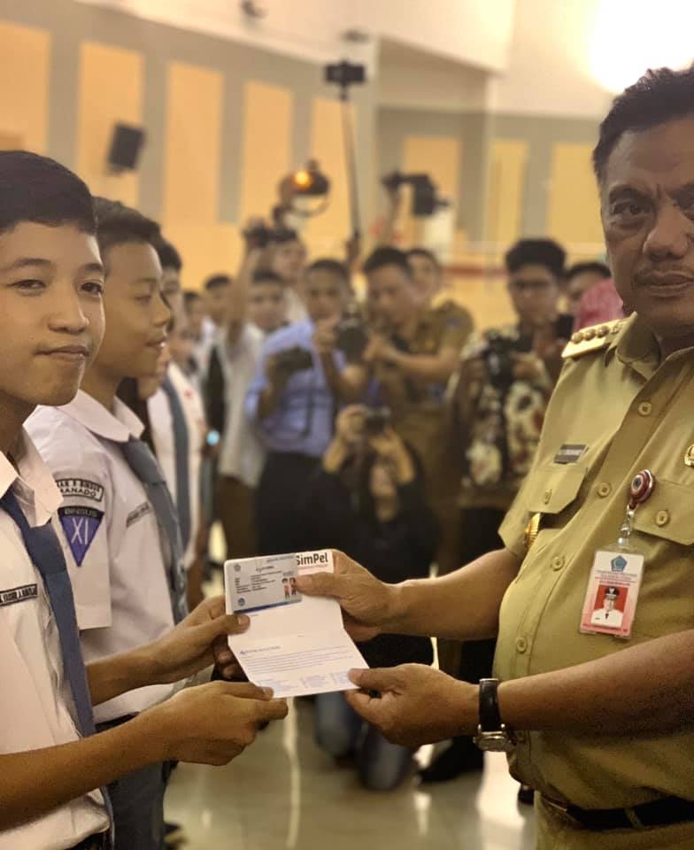 Gubernur Sulut, Olly Dondokambey saat menyerahkan buku tabungan pada siswa. (Foto:Anthony Purukan)