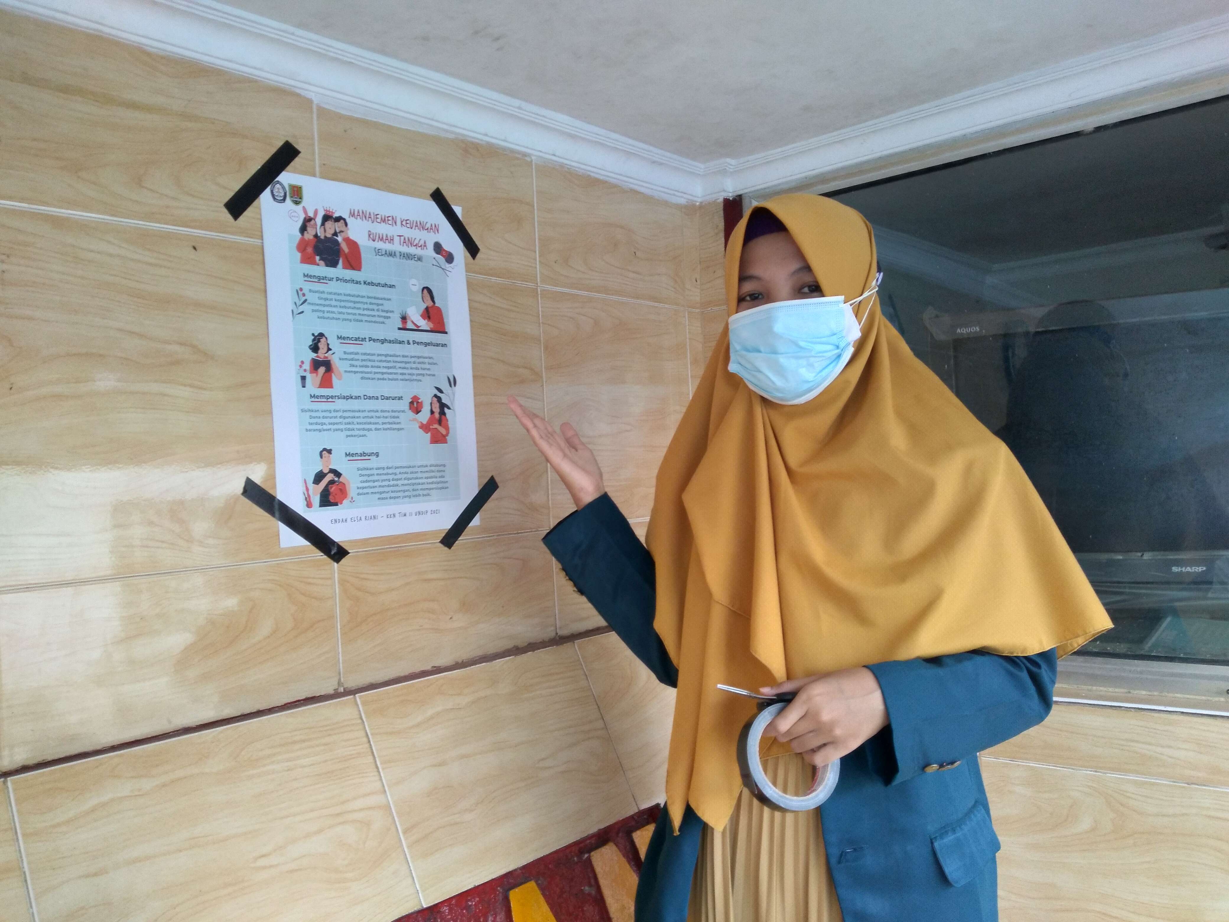 Menempelkan Poster “Manajemen Keuangan Rumah Tangga Selama Pandemi”
