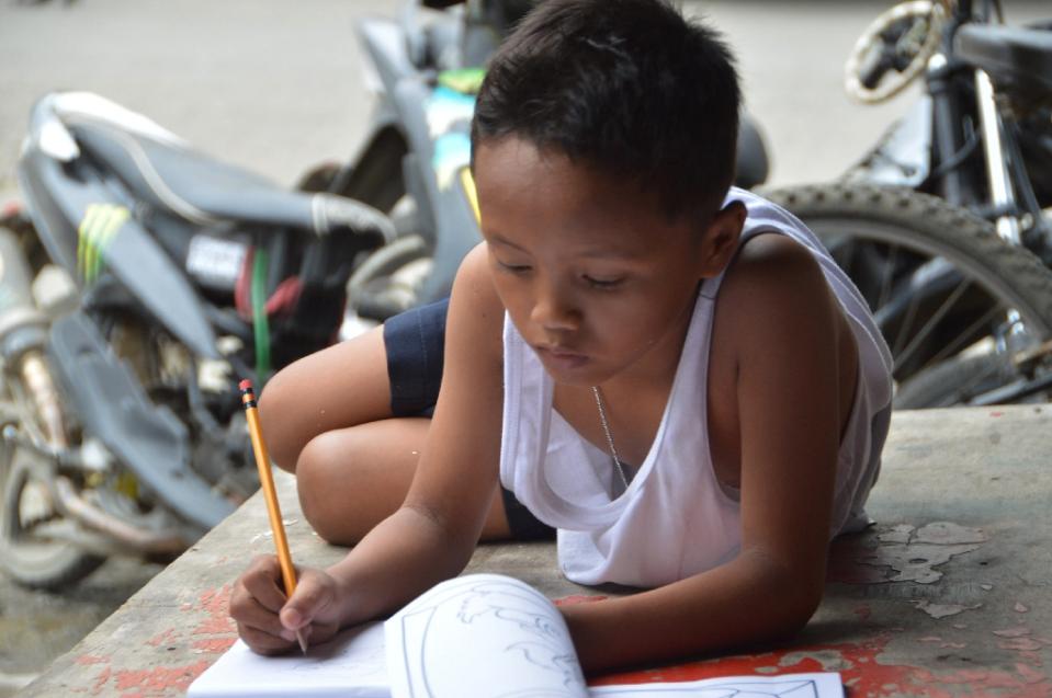 Bocah tunawisma Filipina ini kerjakan PR di jalan, mengharukan!