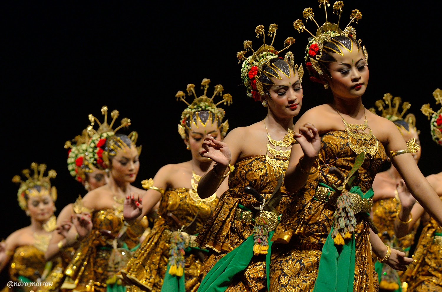  Five female dancers in golden and green traditional Javanese costumes perform the Bedhaya Semang dance, a sacred dance of the Javanese court, accompanied by traditional Javanese gamelan music.