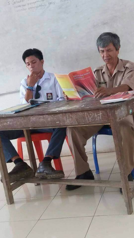 Miris, siswa SMA ini merokok dan duduk tak sopan di samping gurunya
