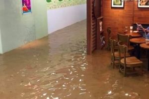 Tak peduli ada banjir besar, kakek ini tetap santai menyeruput kopi