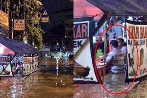 Potret orang makan dengan tenang di tengah banjir ini tuai kontroversi