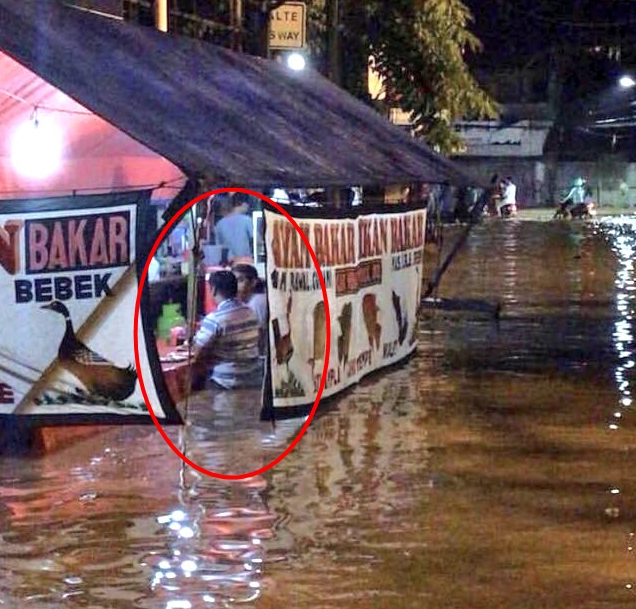 Potret orang makan dengan tenang di tengah banjir ini tuai kontroversi