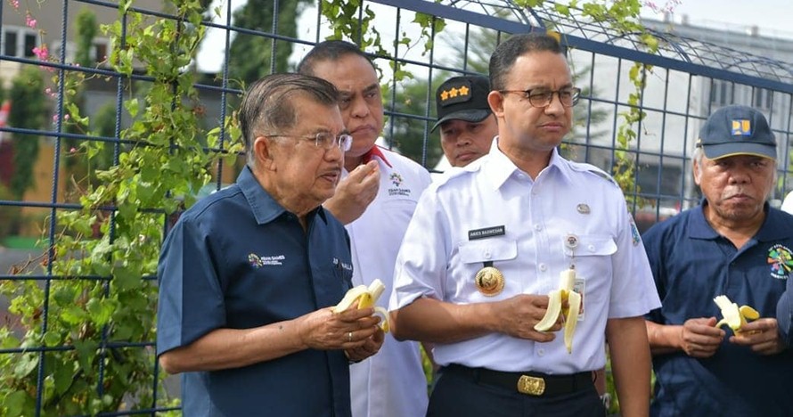 Tunjukkan nggak bau lagi, Anies dan JK makan pisang di tepi Kali Item