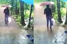 Berjalan menembus hujan, kamu tak akan sangka isi tas plastik pria ini