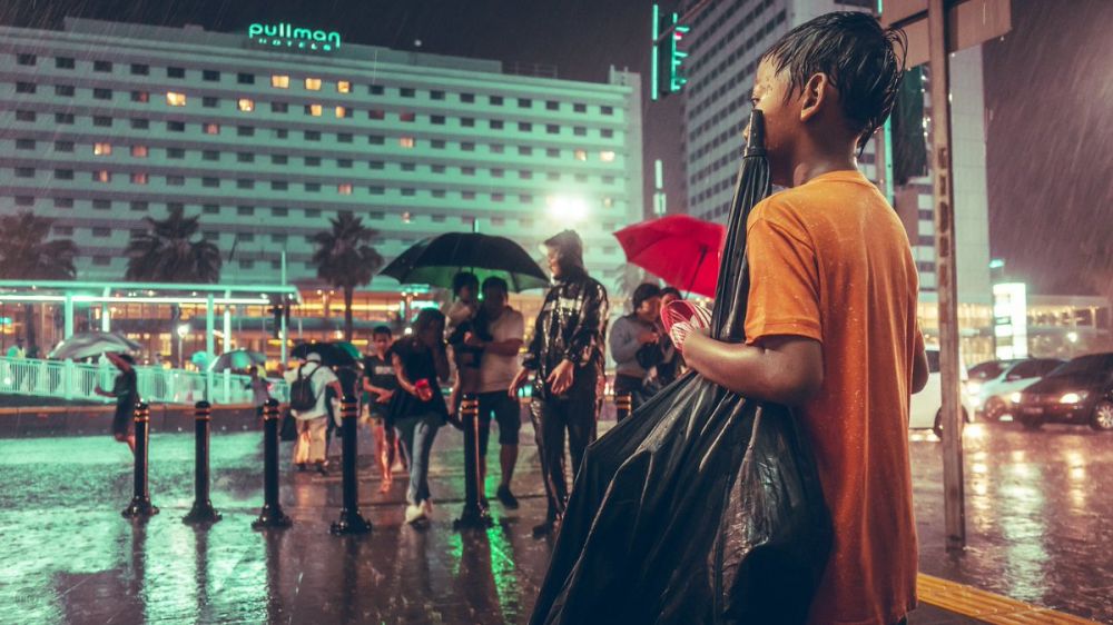 Foto bocah ojek payung ini menyimpan kisah haru di baliknya
