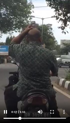 Sunggi air mineral gelas saat motoran, aksi pria ini bikin ngakak