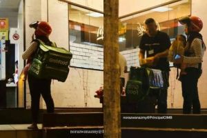 Viral foto ibu ojek online antar makanan sambil gendong bayi