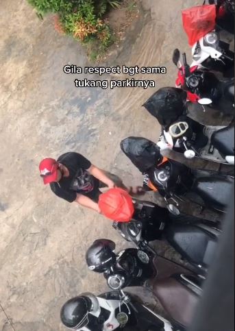 Tukang parkir ini rela basah kuyup demi amankan helm pengunjung, salut