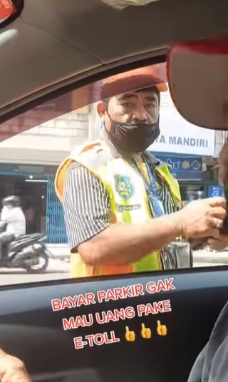 Tukang parkir ini terima pembayaran dengan e-money