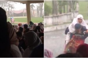 Momen haru anak gendong ibu saat hujan deras jelang sholat Idul Fitri