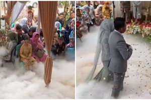 Pengantin berjalan ke pelaminan pakai efek asap, kok kepikiran ya?