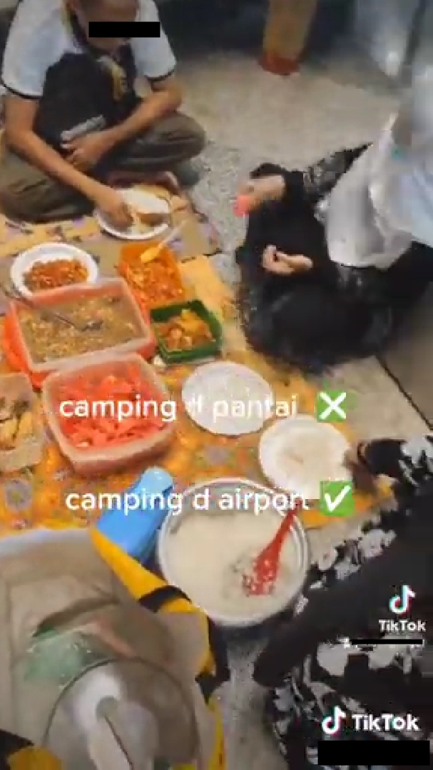 Serasa piknik, satu keluarga makan dan gelar tikar di bandara