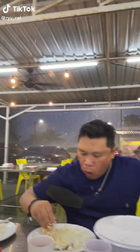 Dua pria ini tetap nikmati makanan saat hujan angin, ekspresinya lucu