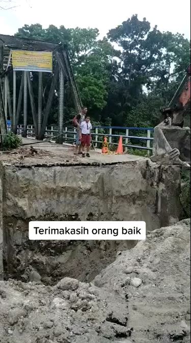 Momen bocah SD ingin berangkat sekolah lewat jembatan putus, dibantu ekskavator untuk menyeberang