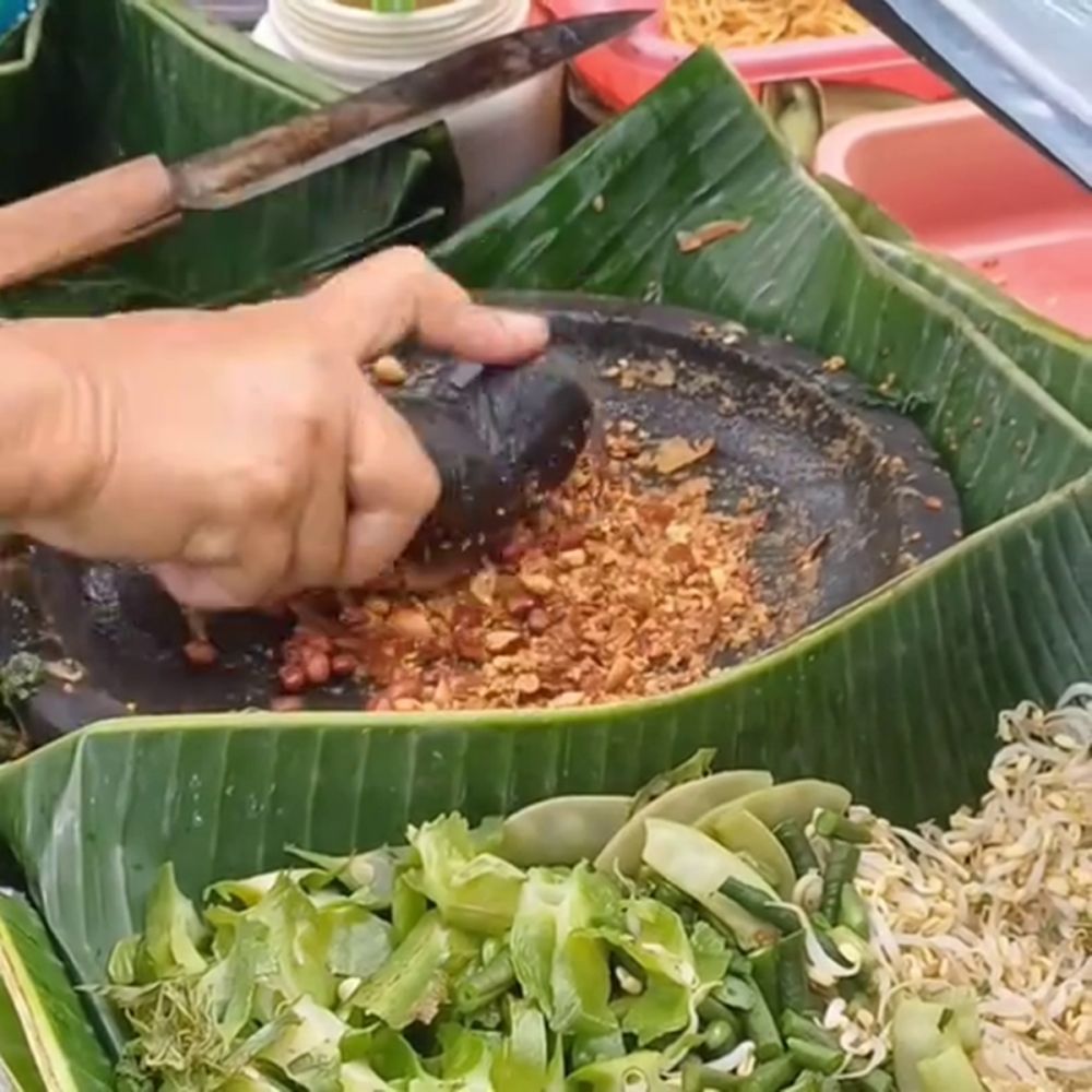 Cara pedagang lotek mengulek bumbu kacang ini 'melawan tradisi', hasilnya ternyata dinilai sempurna