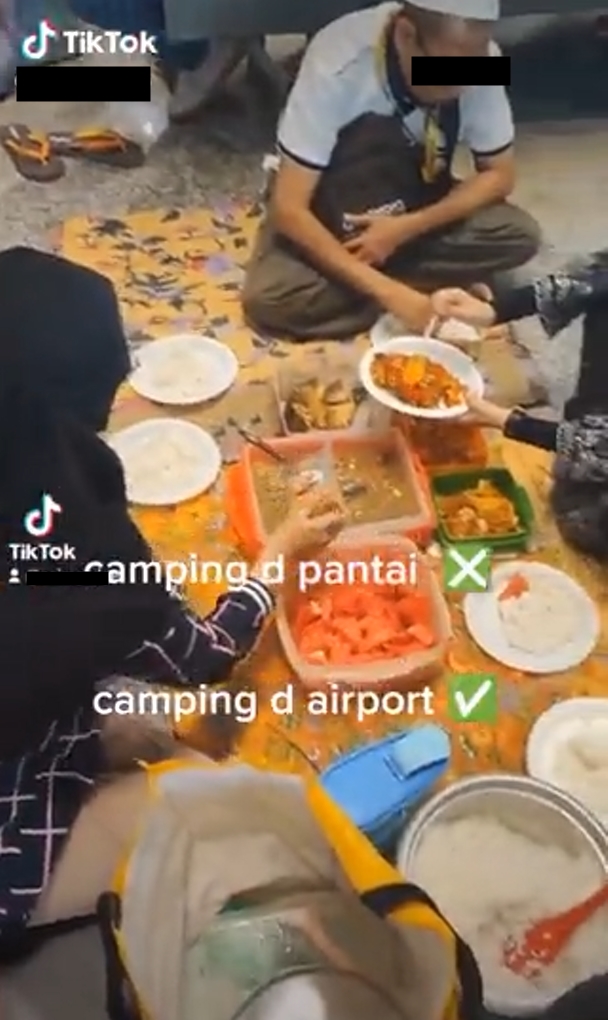 Serasa piknik, satu keluarga makan dan gelar tikar di bandara