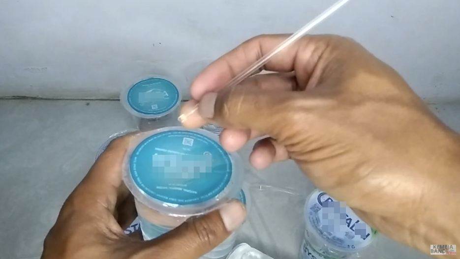 Aksi pria melubangi tutup air kemasan gelas ini kreatif abis, hemat waktu dan nggak bakal tumpah