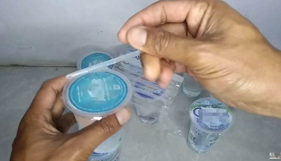 Aksi pria melubangi tutup air kemasan gelas ini kreatif abis, hemat waktu dan nggak bakal tumpah