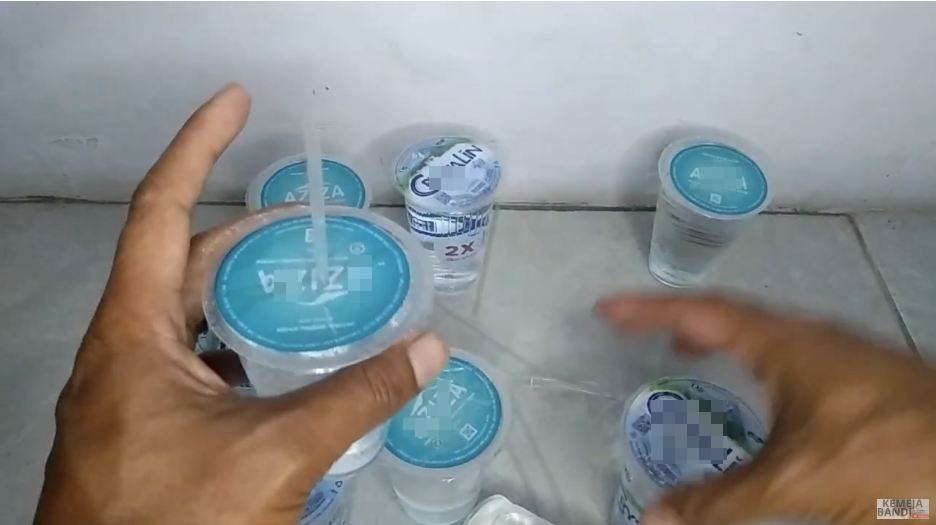 Aksi pria melubangi tutup air kemasan gelas ini kreatif abis, hemat waktu dan nggak bakal tumpah