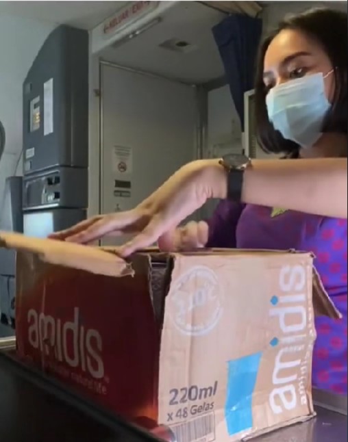 Cara pramugari cantik keluarkan aqua gelas dari kardus ini bikin kagum
