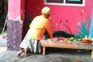 Yuk Ma berjalan pakai lutut di jalan berbatu bawa 2 keranjang makanan