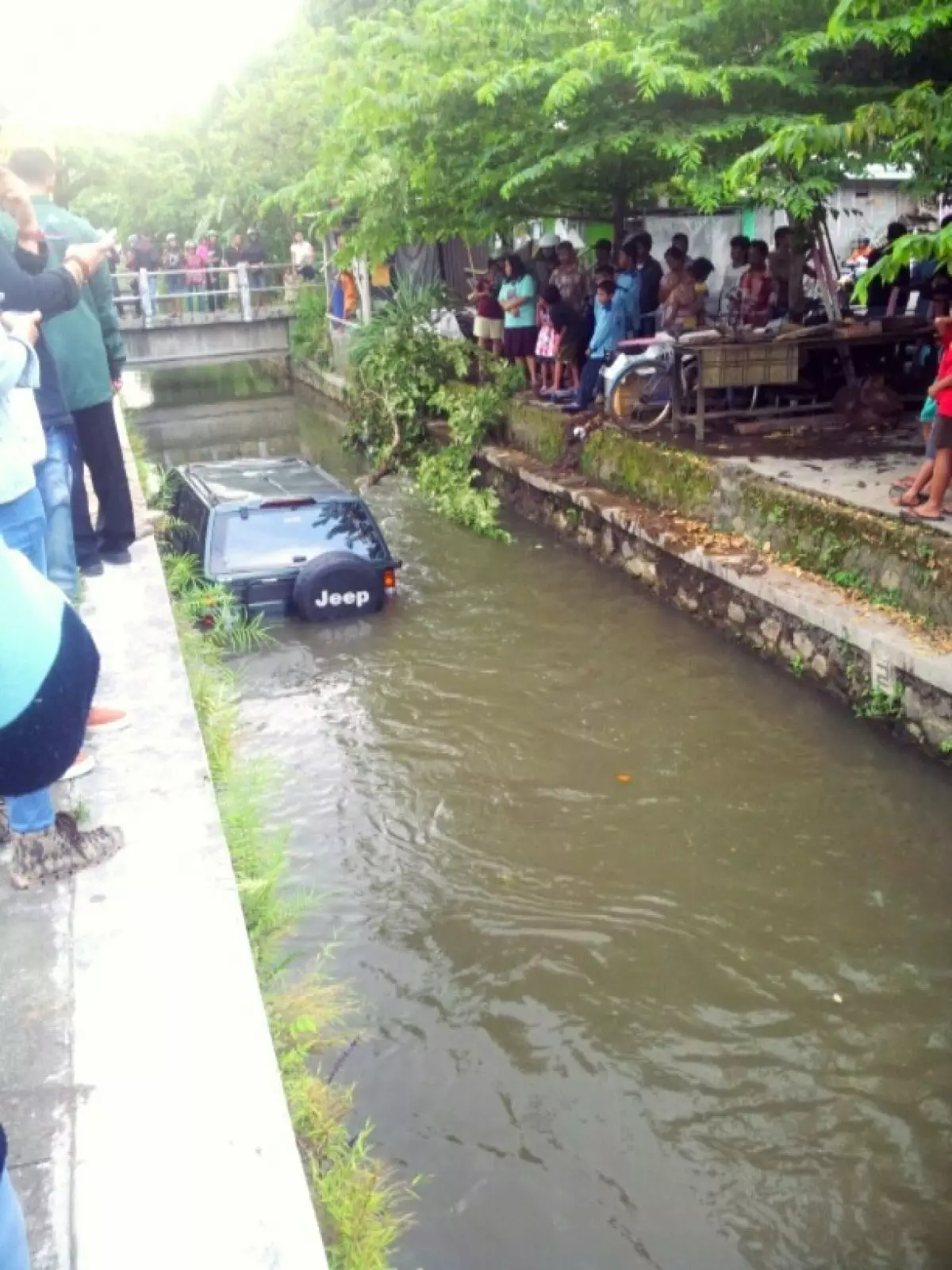 Siang-siang yang panas, mobil ini 'berendam' di sebuah selokan