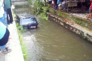 Siang-siang yang panas, mobil ini 'berendam' di sebuah selokan 