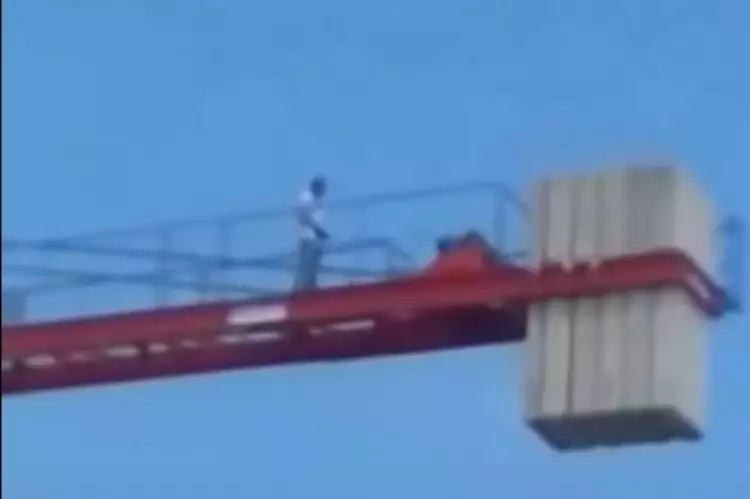 Pekerja bangunan shalat di atas crane