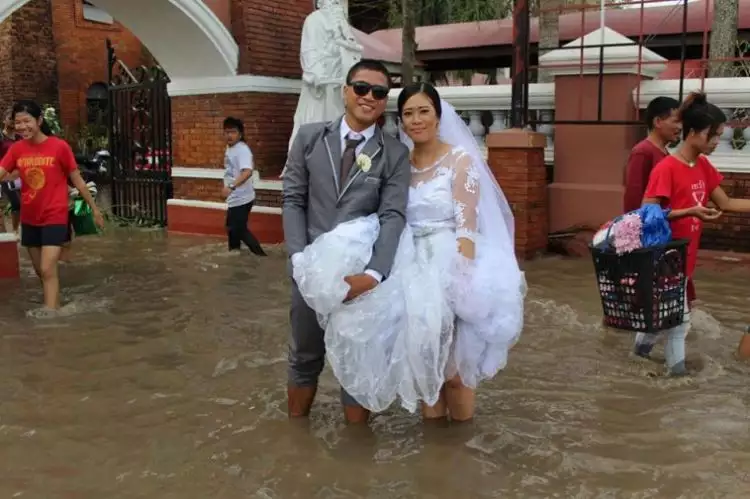 Banjir setinggi lutut, tak menyurutkan niat pasangan ini untuk menikah