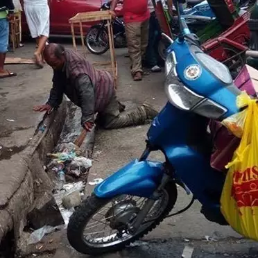 Potret pria tua bersihkan selokan penuh sampah ini bikin hati trenyuh
