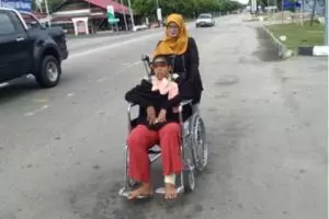 Ibu ini tiap hari dorong kursi roda anaknya sejauh 1 km untuk berobat
