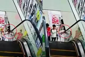 Naik eskalator sambil nengok bawah, gadis ini nyaris kehilangan kepala