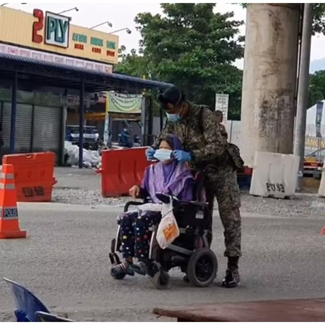 Kisah haru tentara pasangkan masker lansia berkursi roda
