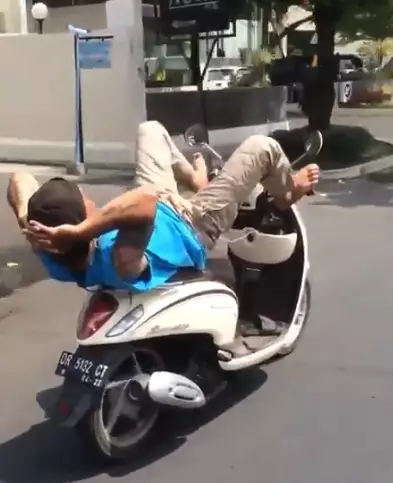 Potret pengendara motor multitasking Berbagai sumber Potret pengendara motor multitasking Berbagai sumber