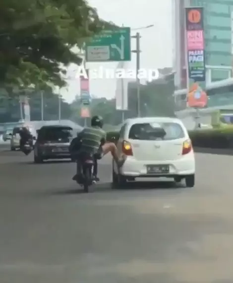 Pengendara motor dorong mobil Instagram/@dramaojol.id Pengendara motor dorong mobil Instagram/@dramaojol.id