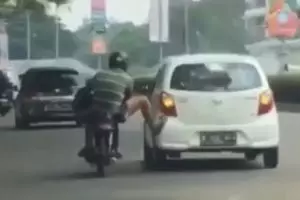 Viral pengendara motor dorong mobil, dijuluki kaki terkuat di bumi