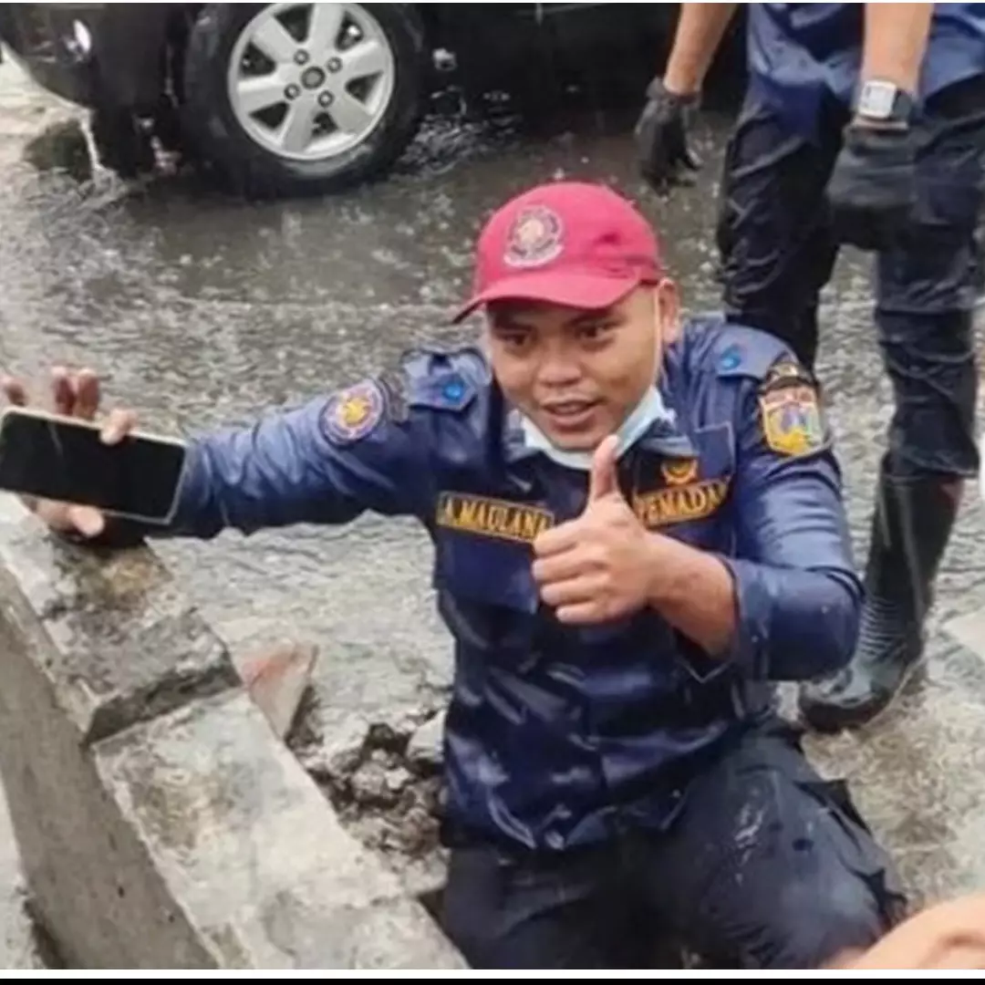 Aksi petugas damkar selamatkan HP warga di got saat hujan, bikin salut