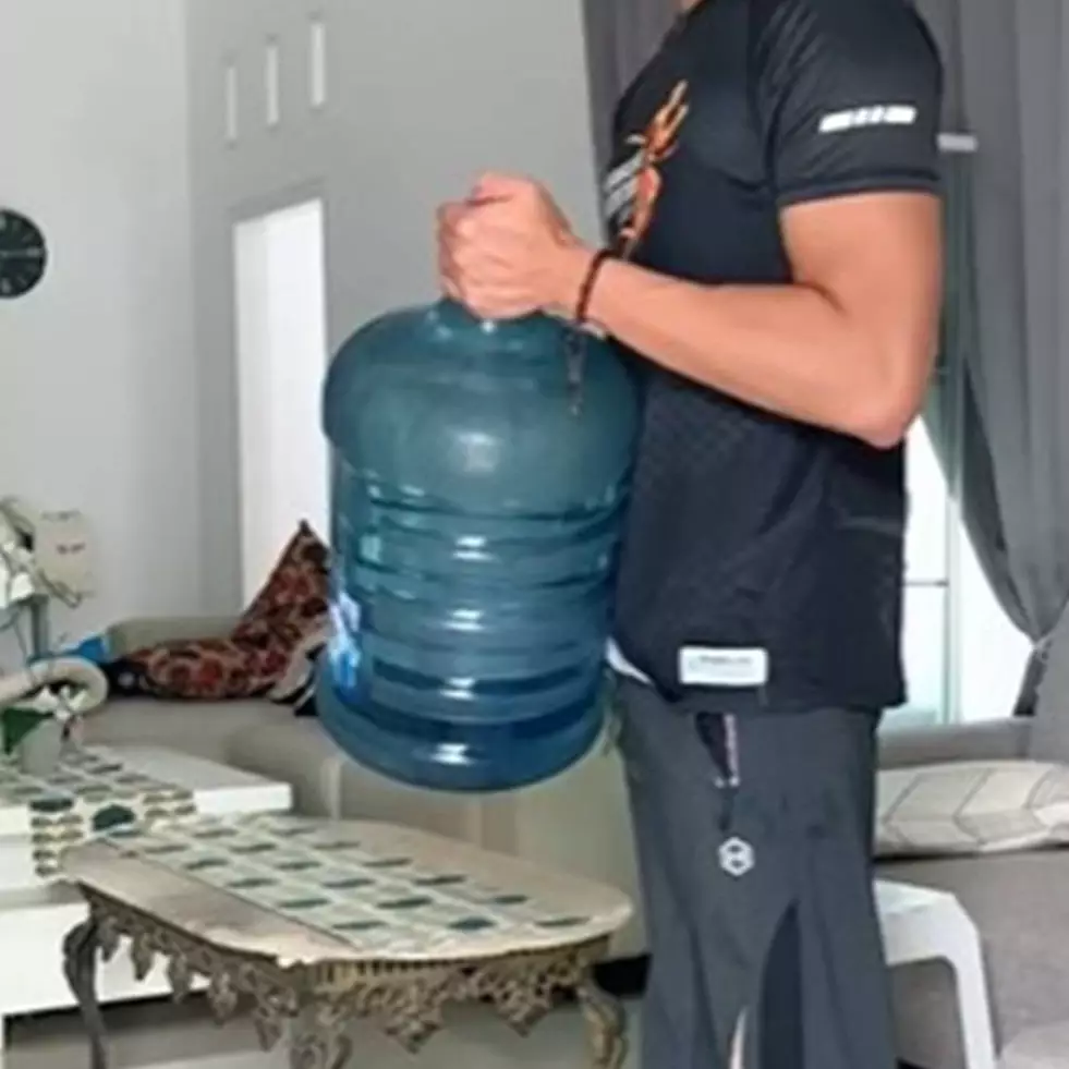 Banyak yang keliru, ini trik angkat galon agar tak bikin saraf kejepit