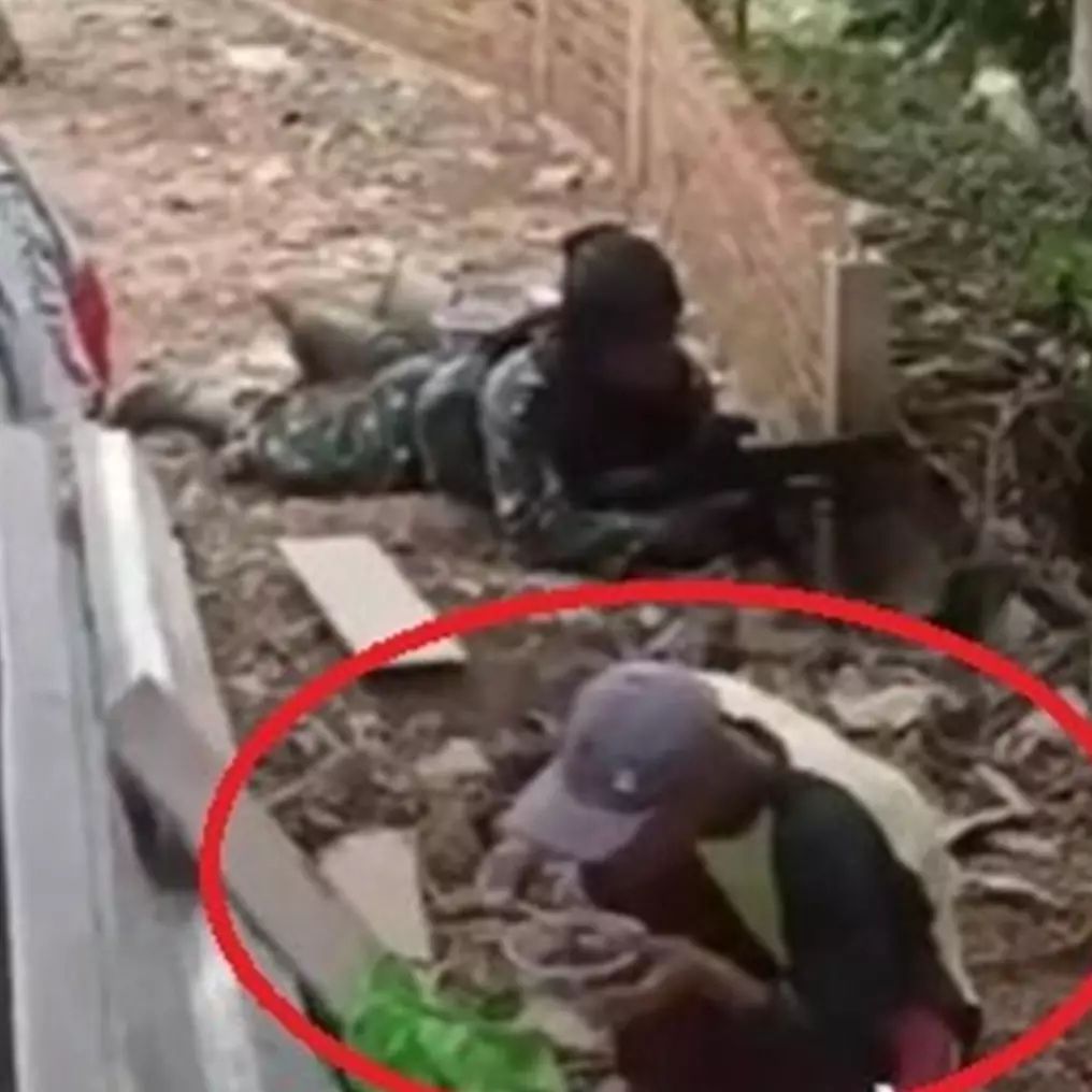 Momen pria makan dengan santai saat tentara latihan perang