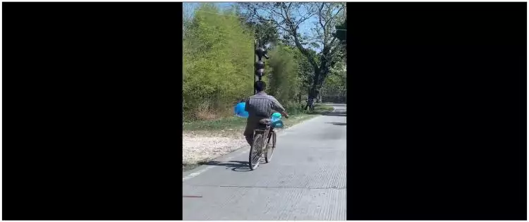 Momen lucu pria pamer skill bawa kendi di atas kepala sambil naik sepeda, aksinya random banget
