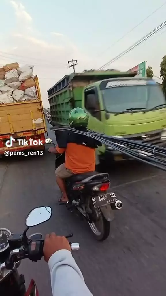 Cara ekstrem bawa batang besi di motor © TikTok Cara ekstrem bawa batang besi di motor © TikTok
