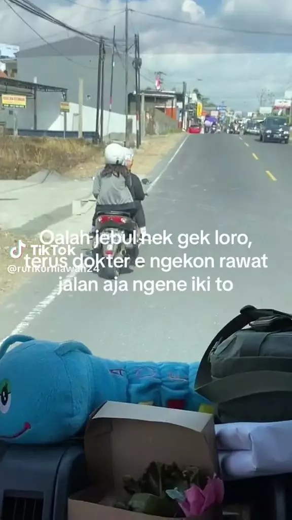 Wanita naik motor sambil diinfus © TikTok