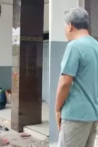 Seorang pria yang diduga tertangkap tangan hendak mengambil peralatan tukang tampak duduk tenang sambil menikmati semangkuk makanan.