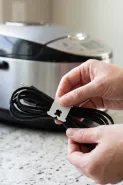 Klip bekas bungkus roti bisa dipakai untuk merapikan kabel rice cooker dan peralatan dapur